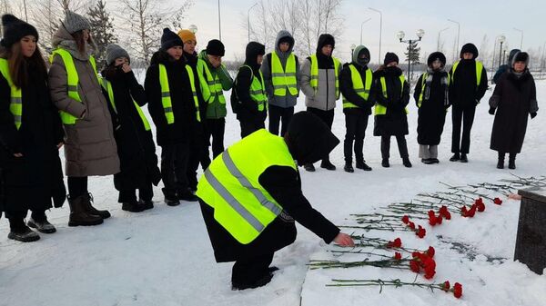 Люди возлагают цветы к мемориалу Добрый Ангел мира в память о погибших при частичном обрушении жилого дома на улице Мира в Нижневартовске