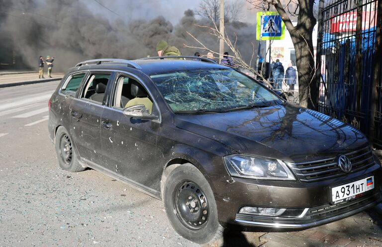 Посеченный осколками автомобиль после обстрела украинскими войсками центрального Ворошиловского района Донецка