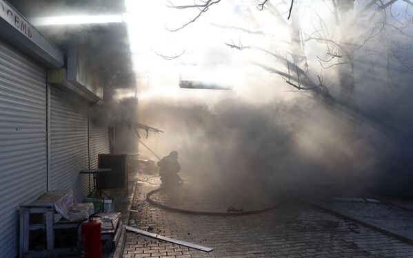Пожарный тушит возгорания после обстрела украинскими войсками центрального Ворошиловского района Донецка