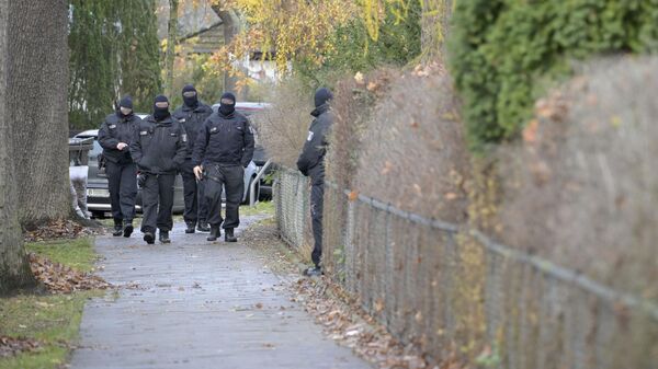Сотрудники немецкой полиции в Берлине во время рейдов против членов крайне правой террористической группы, подозреваемых в планировании нападения на парламент Германии