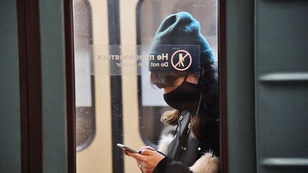 Пассажир в защитной маске в вагоне московского метро