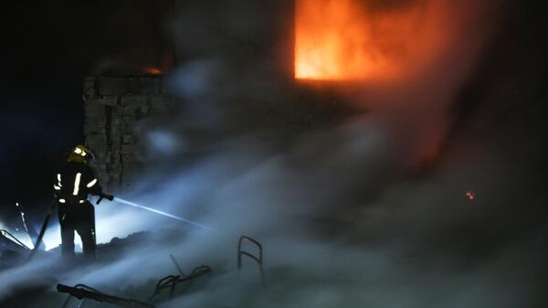 Сотрудник МЧС ликвидирует пожар в Мелитополе после обстрела ВСУ