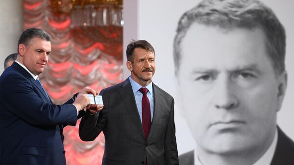 Руководитель фракции ЛДПР Леонид Слуцкий вручает партийный билет новому члену партии Виктору Буту
