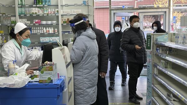 Сотрудник аптеки обслуживает покупателей в Пекине