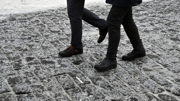 Люди гуляют по Красной площади во время ледяного дождя в Москве