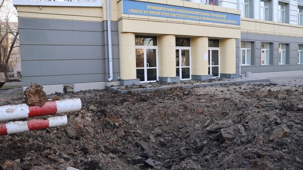 Воронка от взрыва напротив школы в результате обстрела Донецка со стороны ВСУ