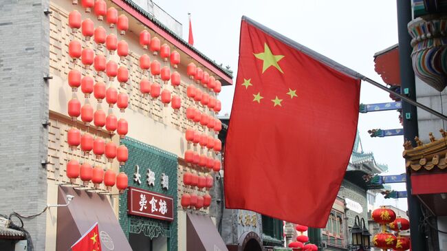 Флаг Китая на доме в историческом центре Пекина в районе Дачжалань в Пекине. Архивное фото