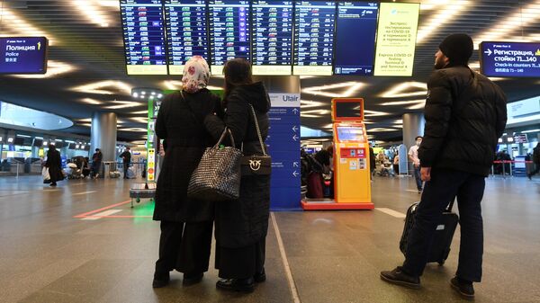 Пассажиры у табло вылетов в аэропорту Внуково в Москве