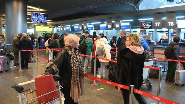 Пассажиры у стойки регистрации вылетов в аэропорту Внуково в Москве