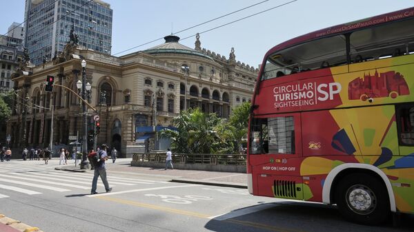 Туристический автобус проезжает мимо Городского театра Сан-Паулу