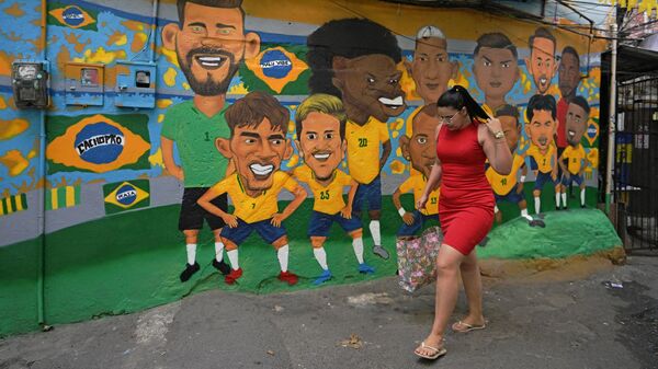 Женщина проходит мимо мурала с изображением сборной Бразилии по футболу в Рио-де-Жанейро
