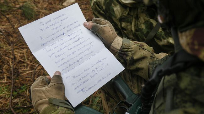 Военнослужащий читает письмо на боевой позиции