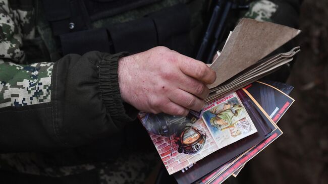 Военнослужащий смотрит письма и рисунки детей 