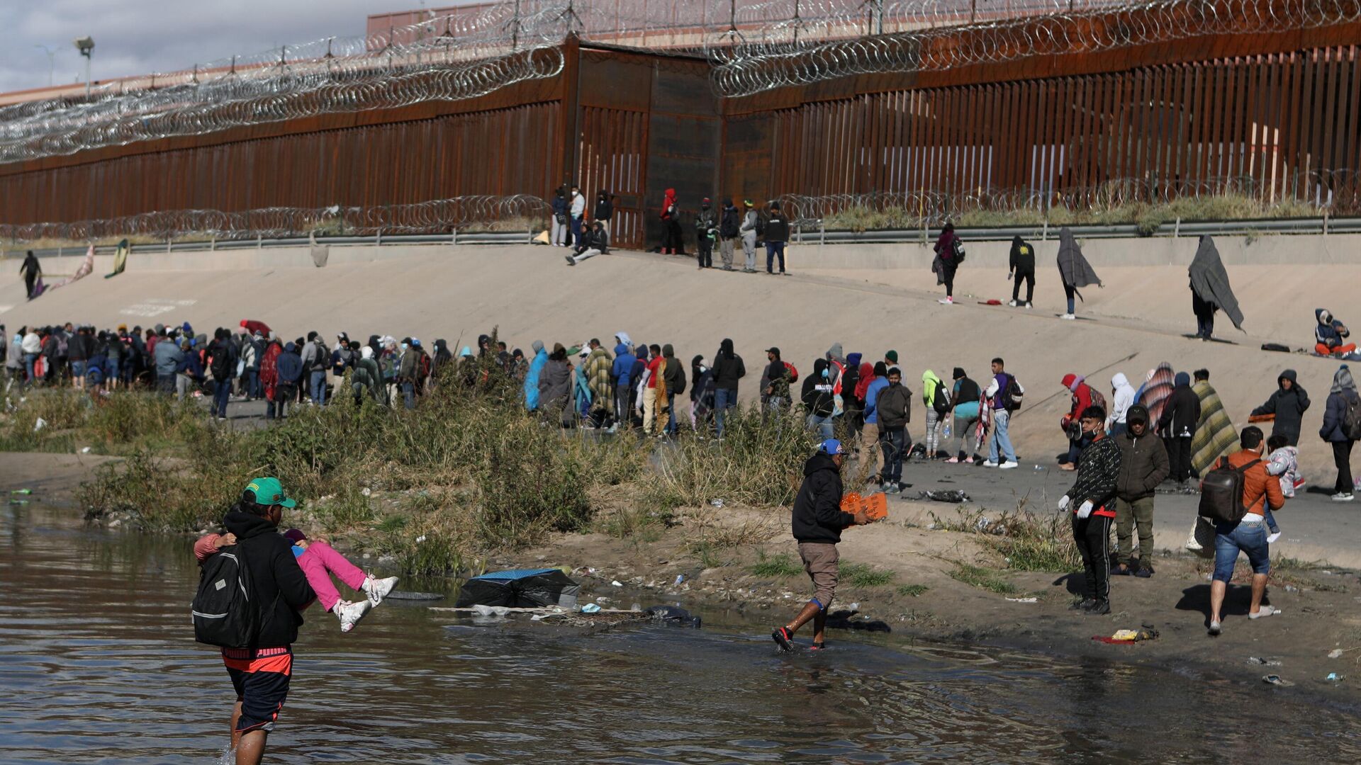 Мигранты переходят через реку Рио-Гранде на пути в пограничный пункт в Эль-Пасо. 13 декабря 2022 - РИА Новости, 1920, 18.12.2022