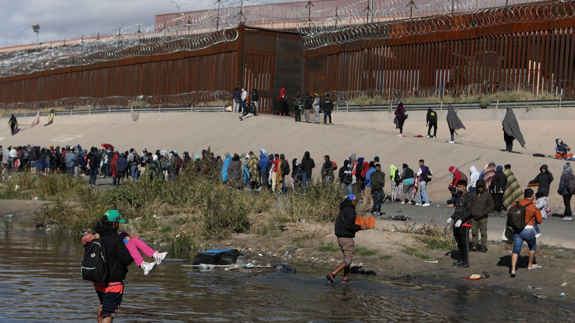 Мигранты переходят через реку Рио-Гранде на пути в пограничный пункт в Эль-Пасо. 13 декабря 2022 - РИА Новости, 1920, 18.12.2022