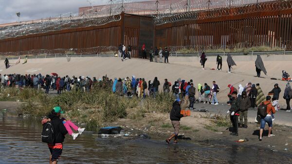 Мигранты переходят через реку Рио-Гранде на пути в пограничный пункт в Эль-Пасо. 13 декабря 2022