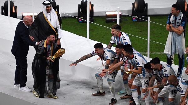 Игрок сборной Аргентины на церемонии награждения победителей чемпионата мира по футболу. Слева направо: президент ФИФА Джанни Инфантино, эмир Катара шейх Тамим бен Хамад Аль Тани и Лионель Месси