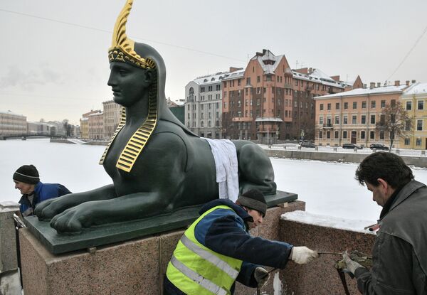 Рабочие устанавливают скульптуры сфинксов на Египетский мост в Санкт-Петербурге после реставрации