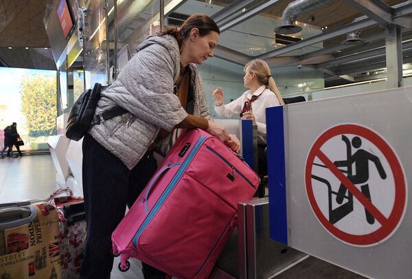Пассажир оформляет багаж во время регистрации на рейс в аэропорту Пулково