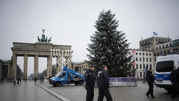 Полицейский у главной рождественской ели Берлина с отпиленной верхушкой