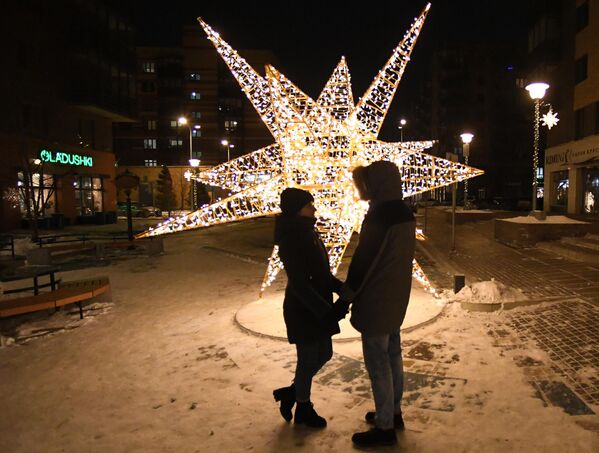 Молодые люди у новогодней инсталляции на бульваре Экзюпери в микрорайоне Южный берег Красноярска