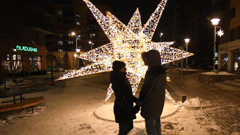 Молодые люди у новогодней инсталляции на бульваре Экзюпери в микрорайоне Южный берег Красноярска