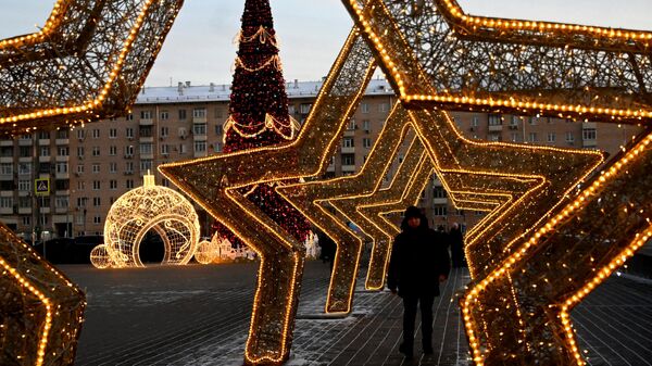 Молодой человек у новогодней инсталляции на Проспекте Вернадского в Москве
