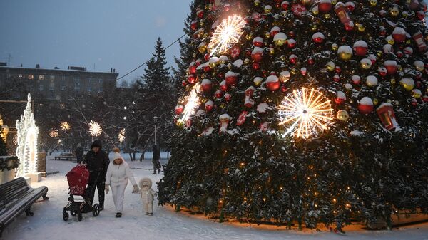 Семья с детьми гуляет у новогодней елки в Театральном сквере на площади Ленина в Новосибирске