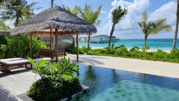 Вид на водные виллы в отеле Hilton Maldives Amingiri Resert & Spa