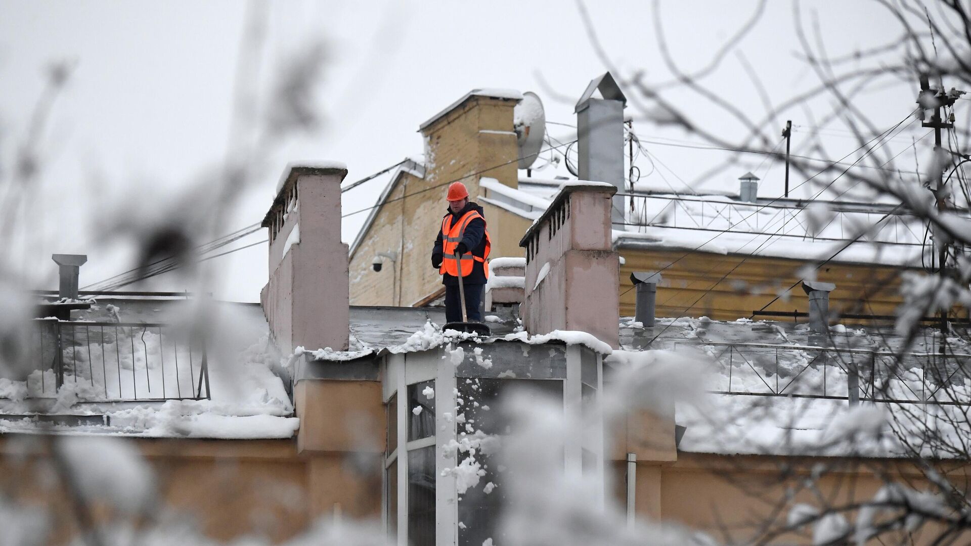 Сотрудник коммунальной службы во время уборки снега с крыши дома в Москве - РИА Новости, 1920, 23.12.2022
