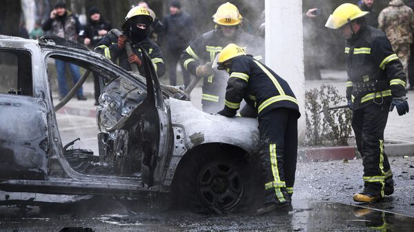 Сотрудники МЧС РФ работают на месте взрыва автомобиля в центре Мелитополя. 23 декабря 2022