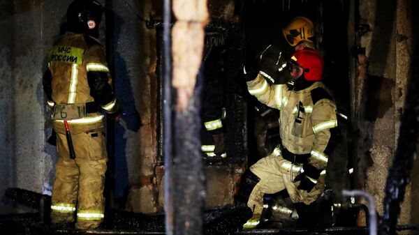 Сотрудники пожарной службы МЧС РФ работают на месте пожара в здании частного дома престарелых в Кемерово