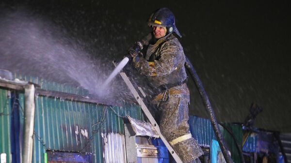 Сотрудник пожарной службы МЧС РФ работают на месте пожара