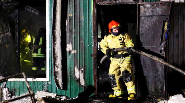 Сотрудники пожарной службы МЧС РФ работают на месте пожара в здании частного дома престарелых на улице Таврическая в Кемерово