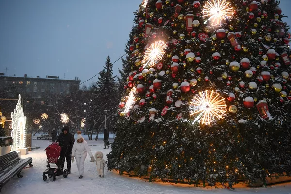 Семья с детьми гуляет у новогодней ёлки в Театральном сквере на площади Ленина в Новосибирске