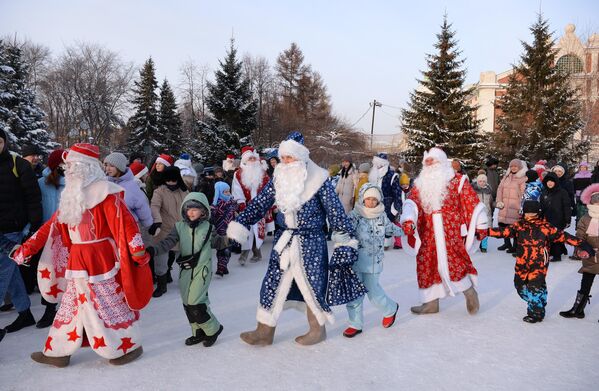 Участники Всероссийского съезда Дедов Морозов водят хоровод во время праздничных мероприятий в Первомайском сквере в Новосибирске