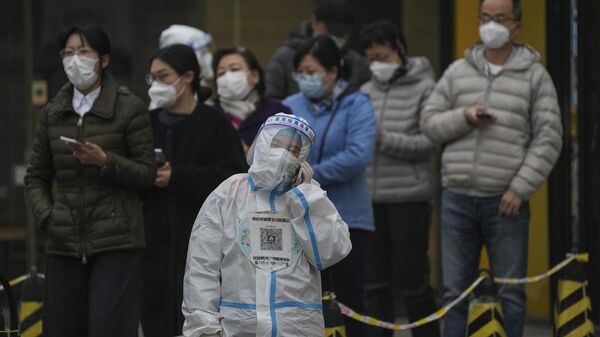 Люди в масках стоят в очереди на тесты на COVID-19 в Пекине