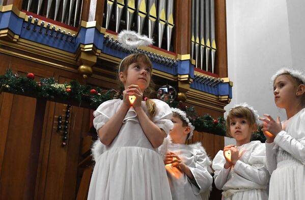 Дети в костюмах ангелов на праздновании католического Рождества в католической церкви пресвятой Богородицы во Владивостоке