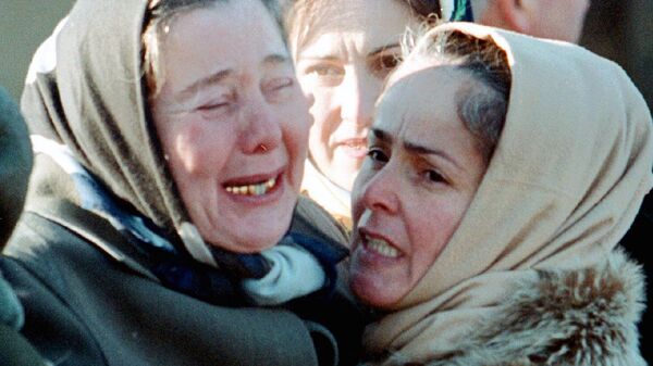 Женщины недалеко от места взрыва у дома правительства в Грозном. 28 декабря 2002