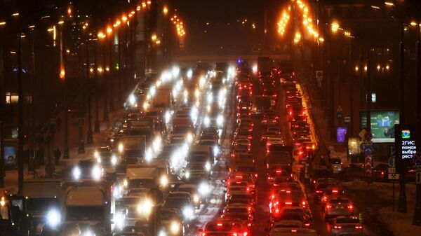 Автомобили едут в плотном потоке по одной из улиц в Москве