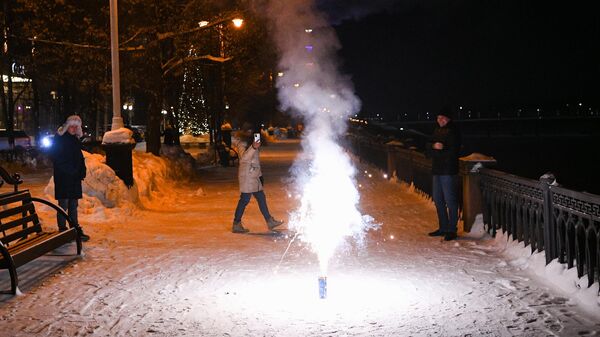 Люди запускают фейерверки во время празднования Нового года
