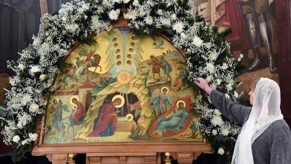 Верующая у иконы Рождество Христово в храме Христа Спасителя в Москве перед началом Рождественского богослужения