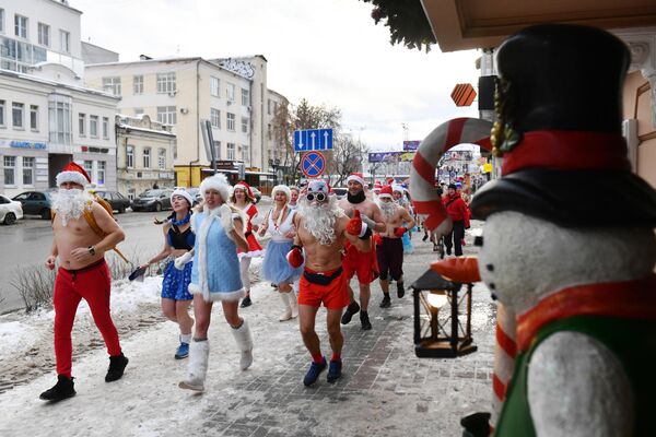 Участники городского клуба закаливания и зимнего плавания во время забега в костюмах Дедов Морозов и Снегурочек в центре Екатеринбурга