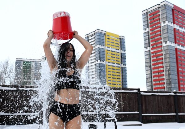 Елена Волкова обливается холодной водой на детской площадке возле своего дома
