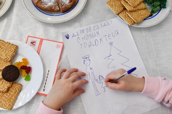 Девочка пишет письмо солдату на фронт во время новогоднего утренника для детей участников СВО
