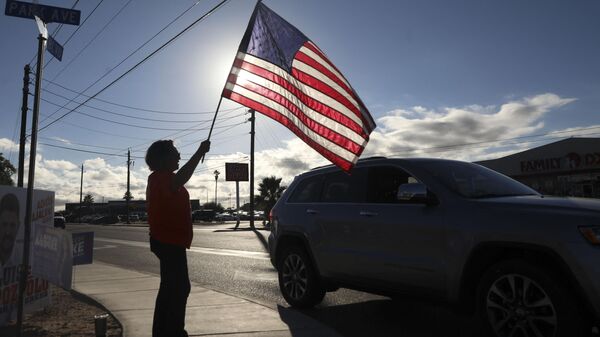 Женщина машет американским флагом в штате Аризона в США