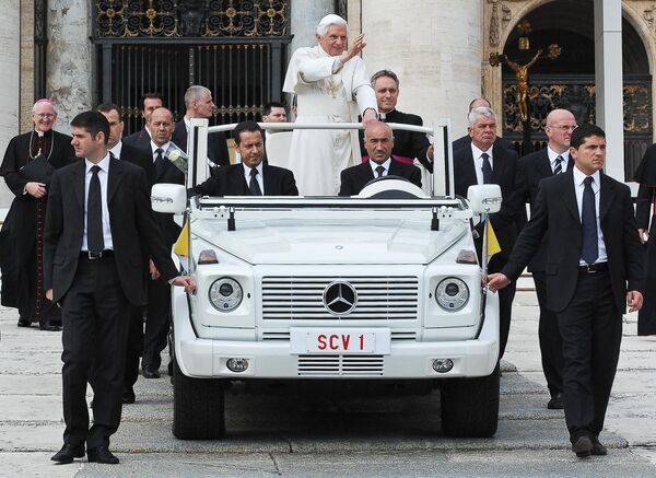 Папа Римский Бенедикт XVI машет рукой верующим, собравшимся на площади Святого Петра в Ватикане