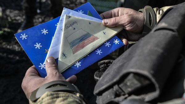 Военнослужащий Вооруженных сил РФ, участвующий в боевых действиях на Запорожском направлении, держит поздравительные письма на передовой