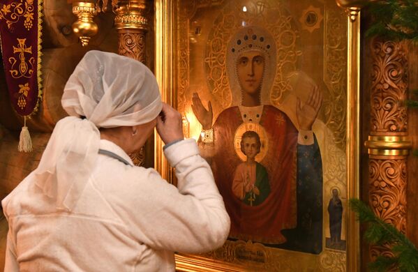 Верующая во время ночной Рождественской службы в Знаменском православном храме в Дивногорске