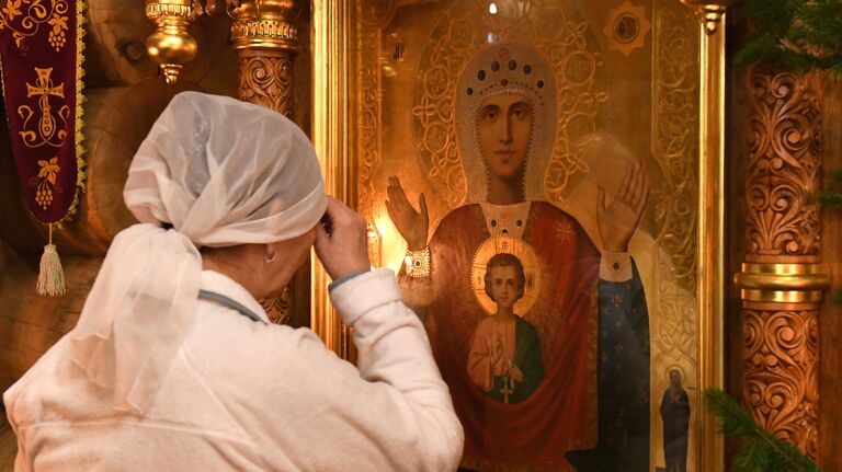 Верующая во время ночной Рождественской службы в Знаменском православном храме в Дивногорске